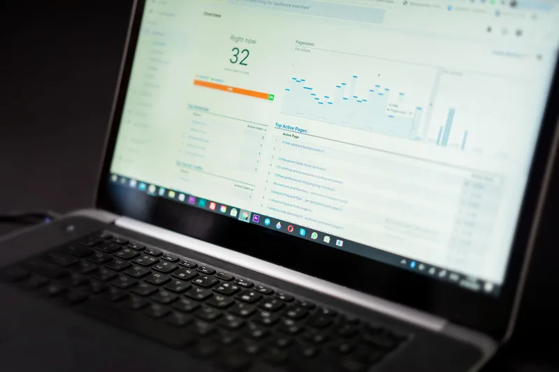 Laptop screen displaying a real-time analytics dashboard with visitor and pageview data