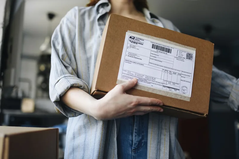 Shipping label generation in an OMS showing carrier selection between Ninja Van SG, J&T Express SG and SingPost with automatic tracking number return for a Singapore ecommerce order