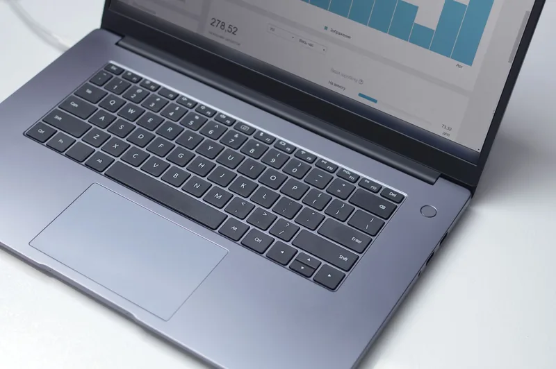 Laptop displaying an analytics dashboard on a desk in a bright office, representing software-based purchase order tracking