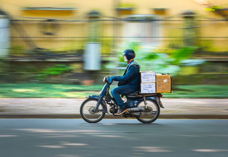 Courier rider collecting packed parcels from a Philippine ecommerce warehouse for same-day dispatch