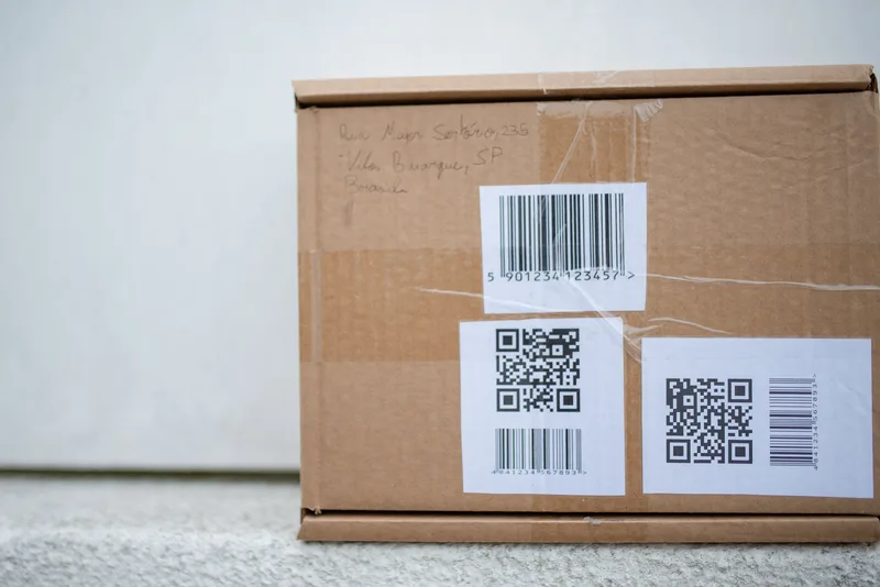 Cardboard parcel with a barcode label and two QR code labels